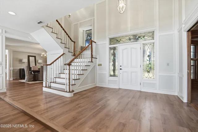 a living room with furniture large window and wooden floor