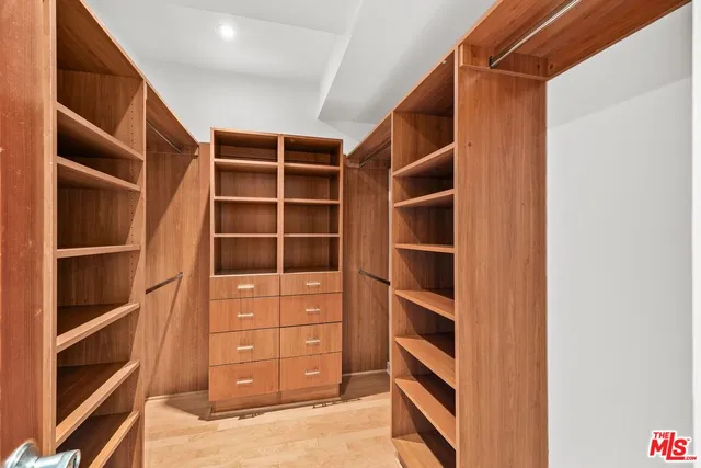 a view of walk in closet with empty racks