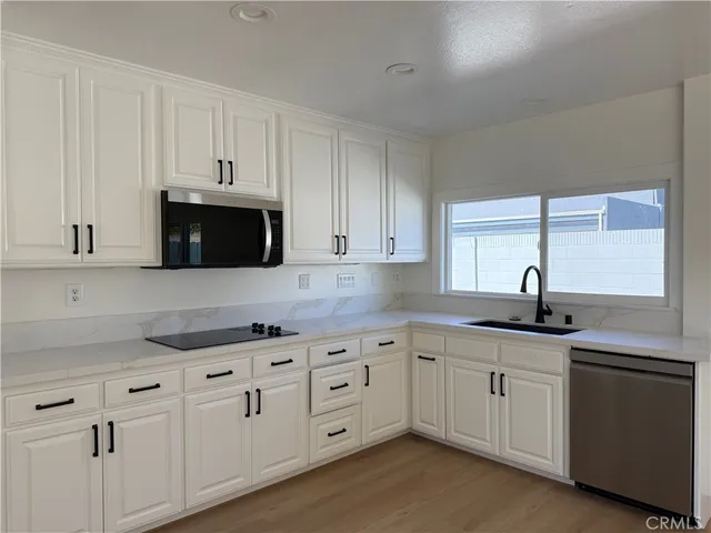a kitchen with white cabinets sink and dishwasher