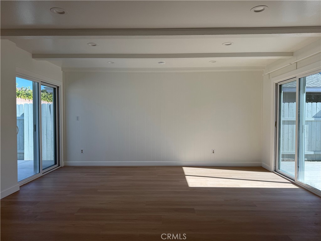 6441 St Paul Circle, Unit A Huntington Beach, CA 92647 - Photo 6 of 13 an empty room with wooden floor and windows