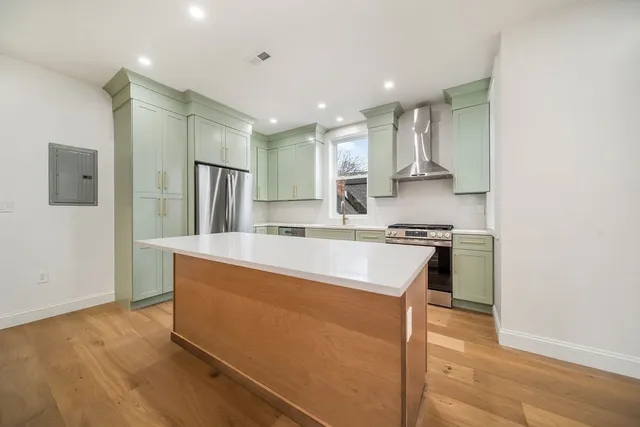 a large kitchen with stainless steel appliances granite countertop a stove a sink and a refrigerator