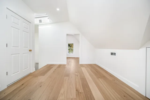 an empty room with wooden floor and window