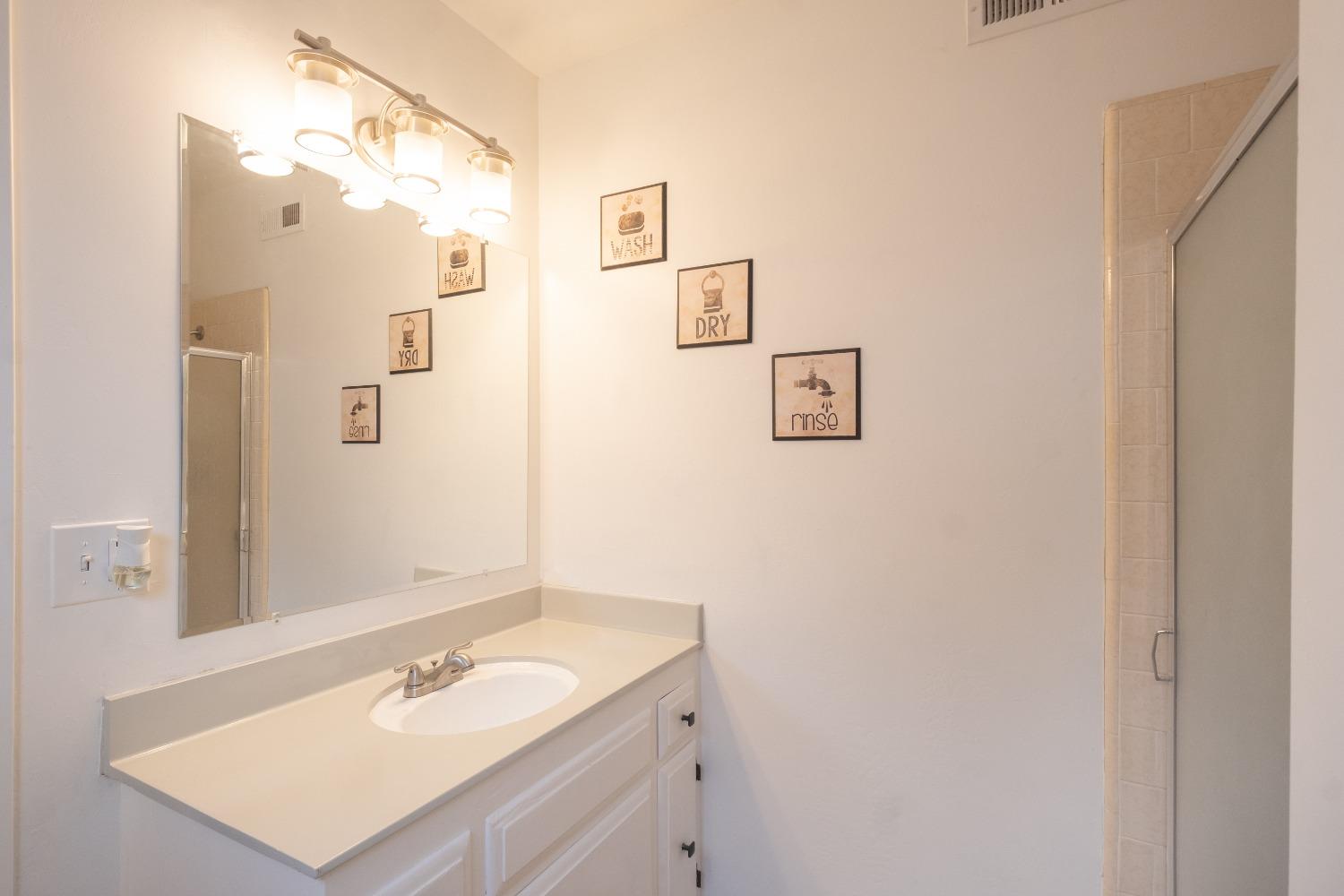 2248 Sunnyside Avenue Clovis, CA 93612 - Photo 12 of 25 a bathroom with a sink vanity and a mirror