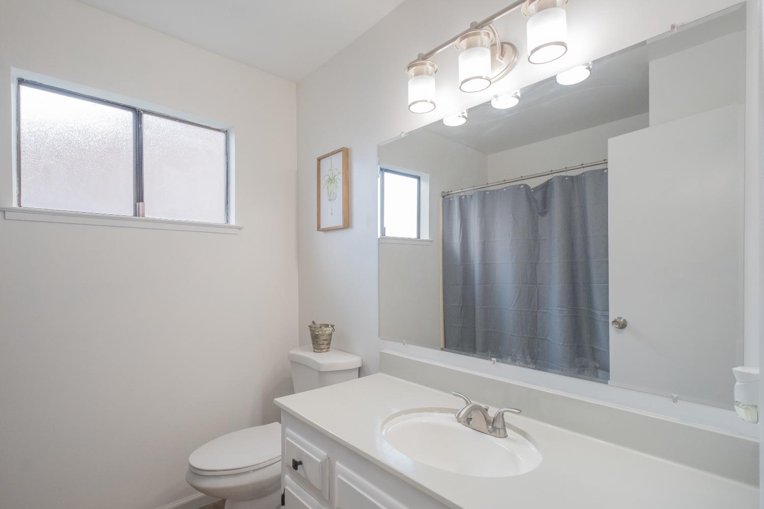 2248 Sunnyside Avenue Clovis, CA 93612 - Photo 15 of 25 a bathroom with a sink a toilet and mirror