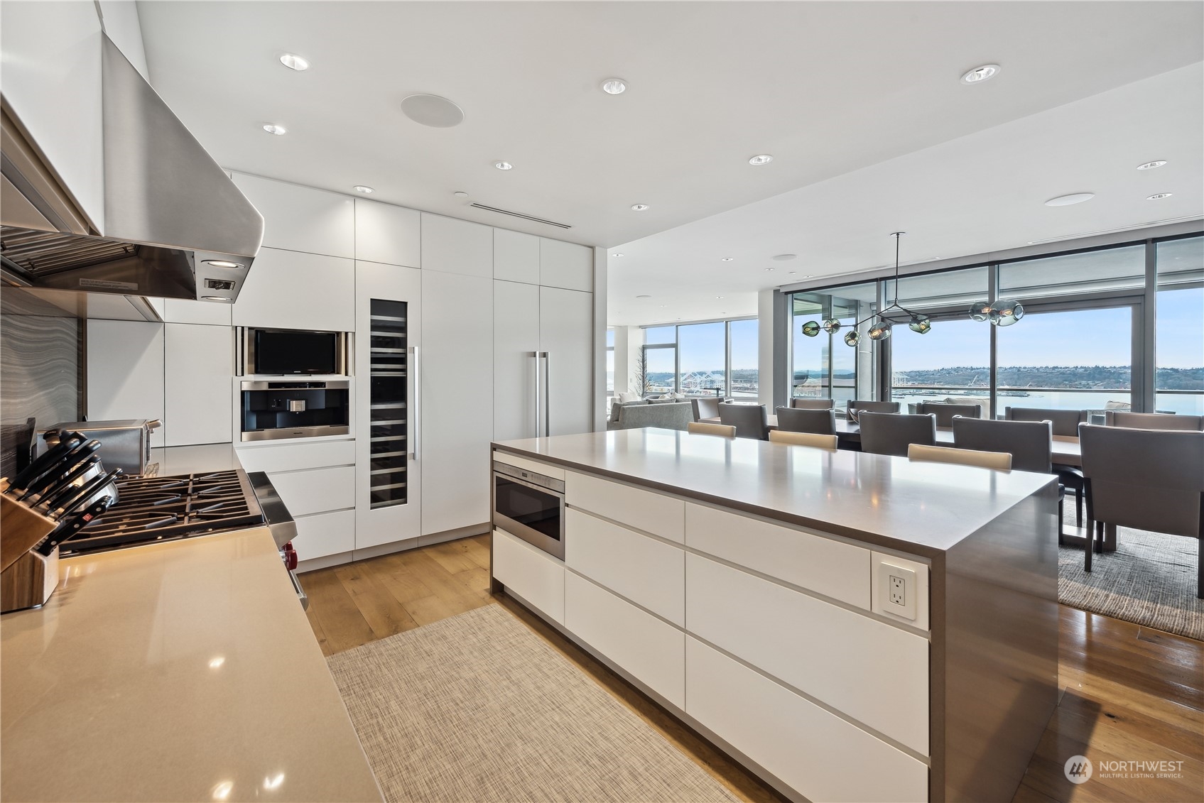 a kitchen with stainless steel appliances a stove a sink a microwave a refrigerator and white cabinets