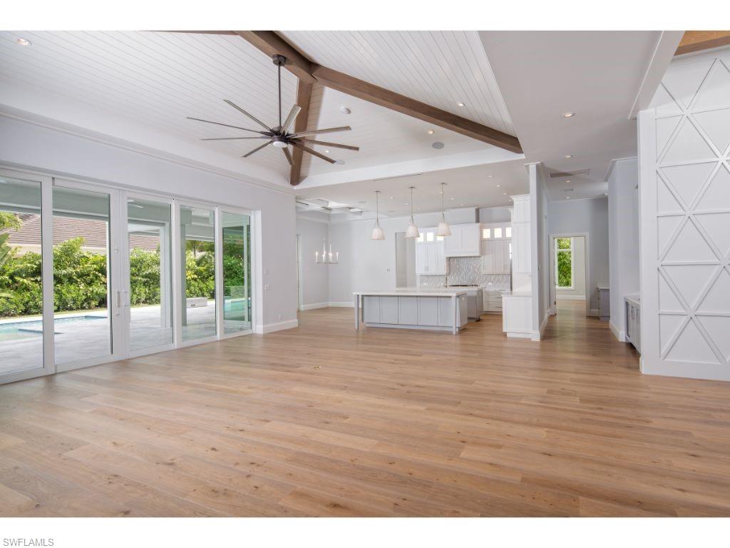 575 Yucca Road Naples, FL 34102 - Photo 4 of 16 a view of an empty room with wooden floor and a window