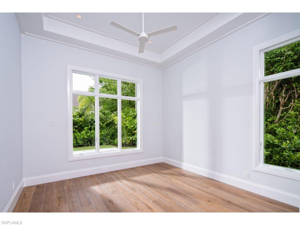 575 Yucca Road Naples, FL 34102 - Photo 8 of 16 an empty room with wooden floor and windows