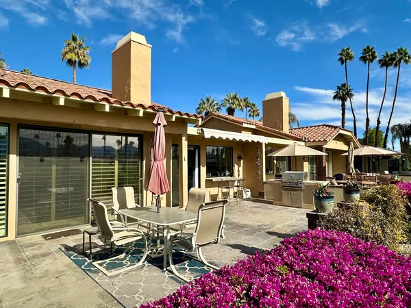 a view of a patio with table and chairs potted plants