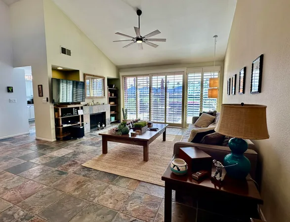 a living room with furniture and floor to ceiling windows