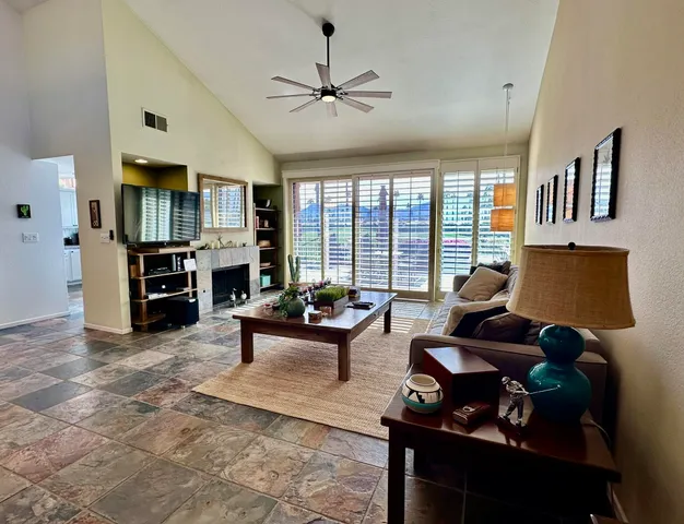 a living room with furniture and floor to ceiling windows