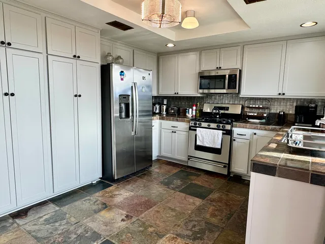 a kitchen with stainless steel appliances granite countertop a stove a sink and a granite counter tops