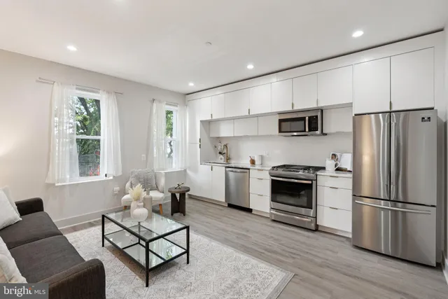 a kitchen with cabinets stainless steel appliances a sink and a window