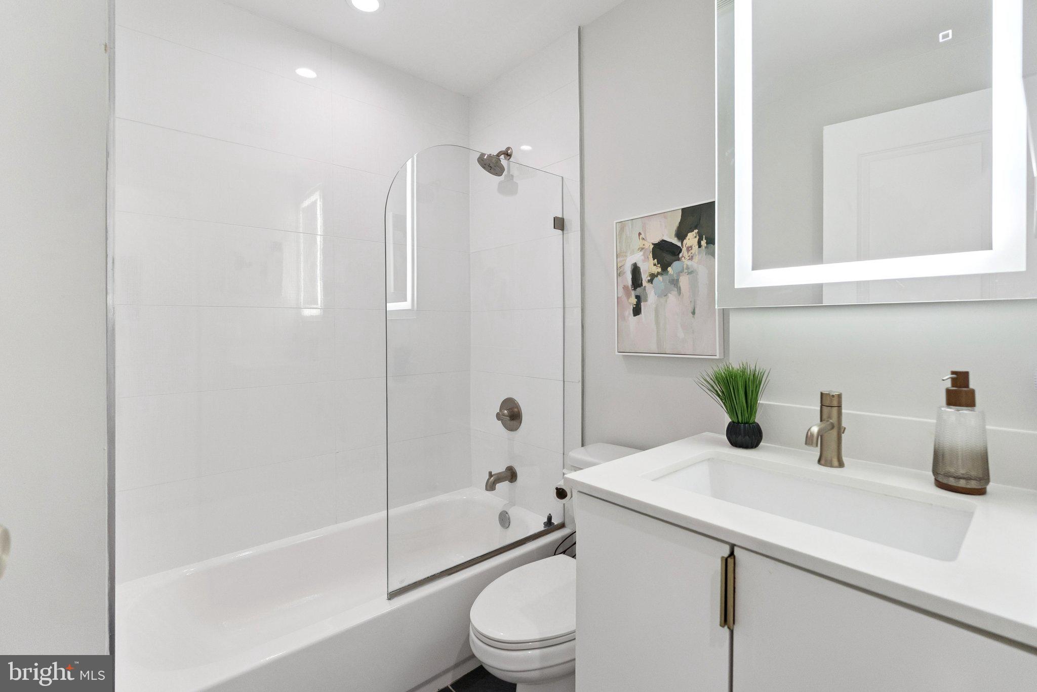 839 Kennedy Street Northwest, Unit 105 Washington, DC 20011 - Photo 14 of 21 a bathroom with a sink a toilet and shower