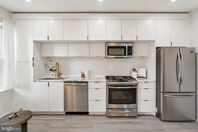 a kitchen with stainless steel appliances a stove a microwave and a refrigerator