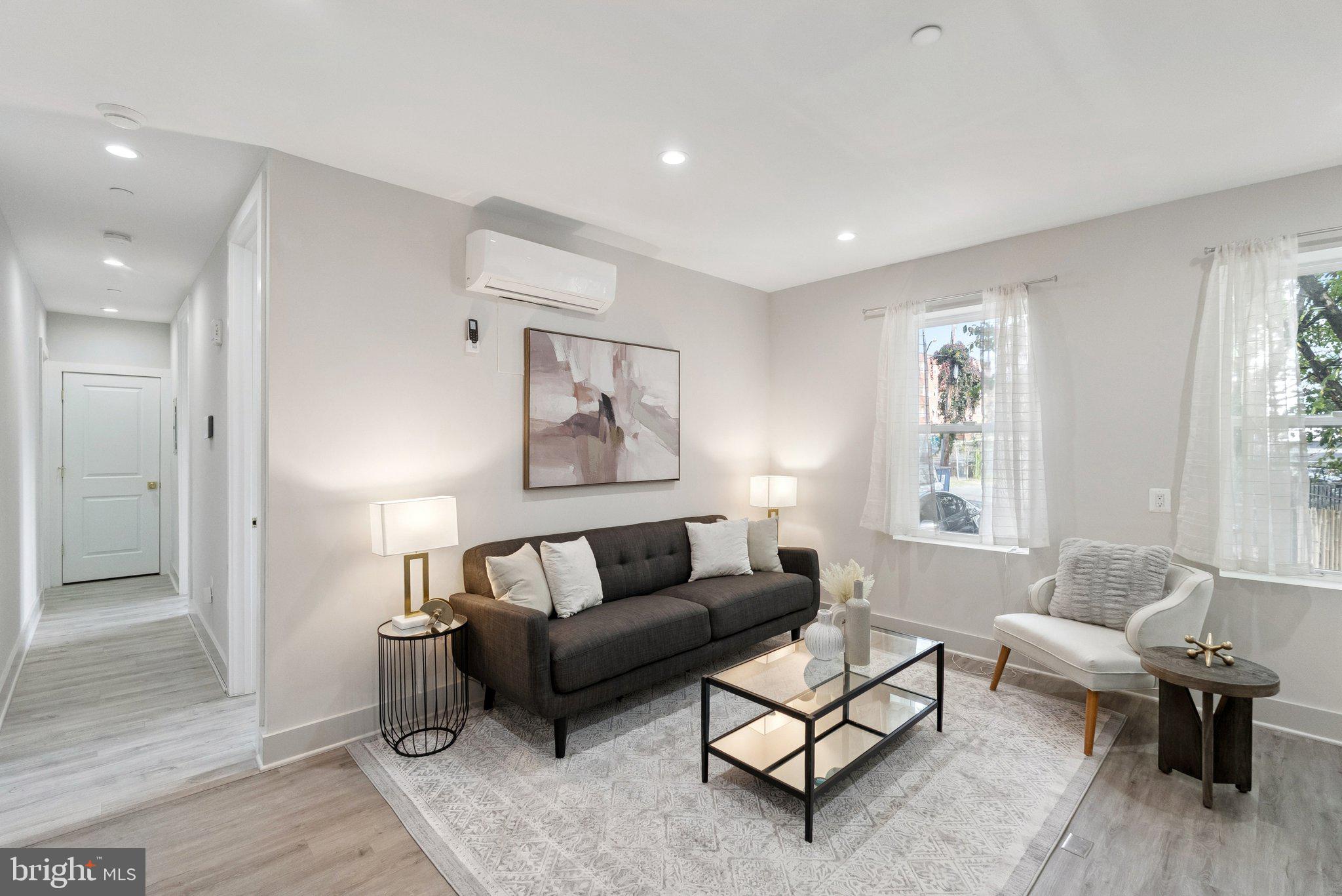 839 Kennedy Street Northwest, Unit 105 Washington, DC 20011 - Photo 6 of 21 a living room with furniture and a potted plant next to a window