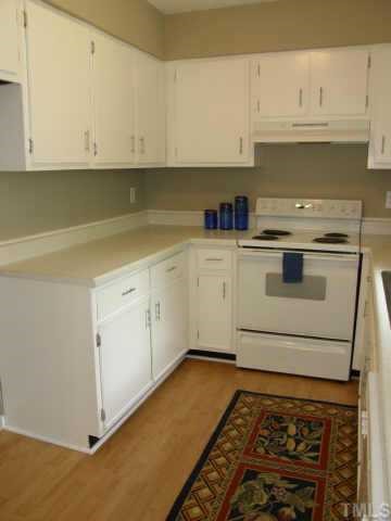 4282 Lake Ridge Drive Raleigh, NC 27604 - Photo 6 of 12 a kitchen with granite countertop white cabinets and white appliances