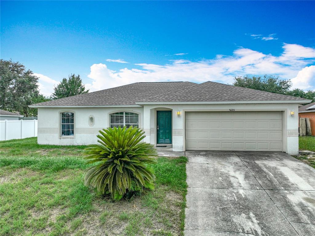 a front view of house with yard and trees around