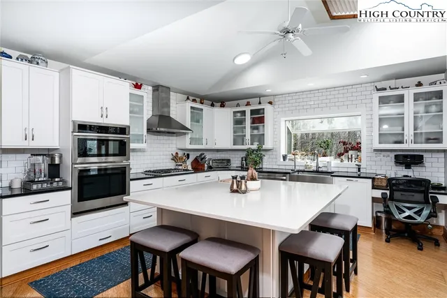 a kitchen with stainless steel appliances a stove a sink a table and chairs