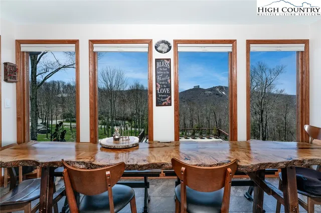 a dining room with furniture and a large window