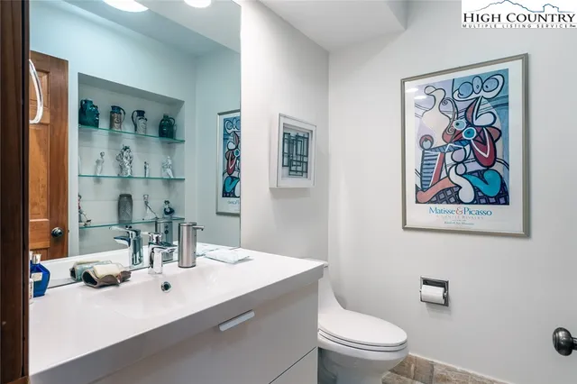 a bathroom with a toilet a sink and mirror