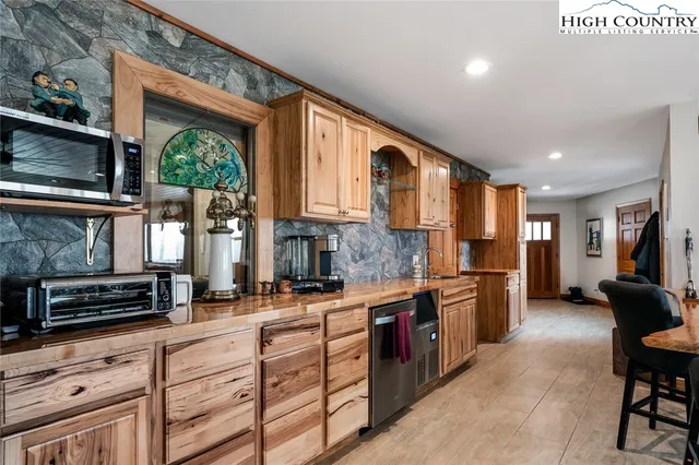 a kitchen with stainless steel appliances kitchen island granite countertop a stove a sink and a microwave