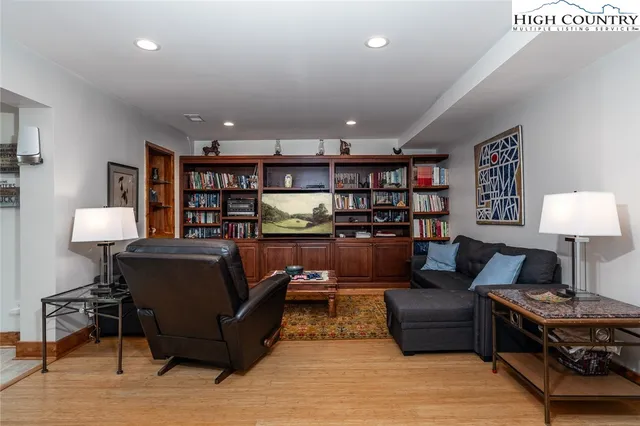 a living room with furniture a lamp and a bookshelf