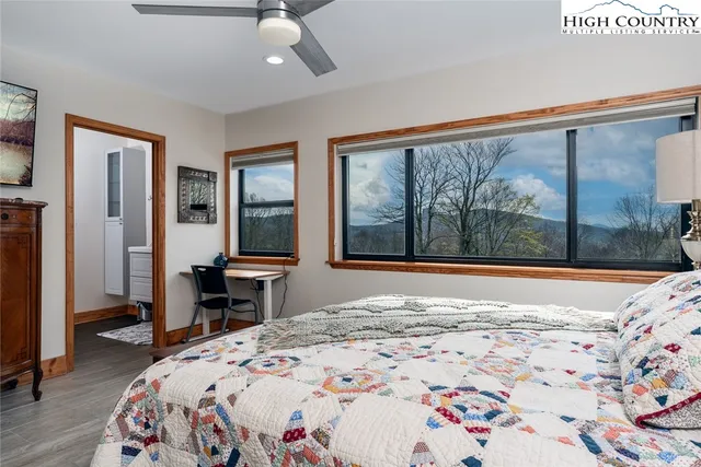 a bedroom with a bed and a large window with chair