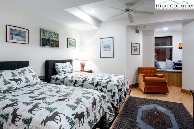 a bedroom with two beds and painting on the wall