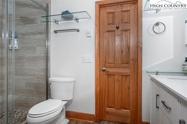 a bathroom with a granite countertop toilet and a shower