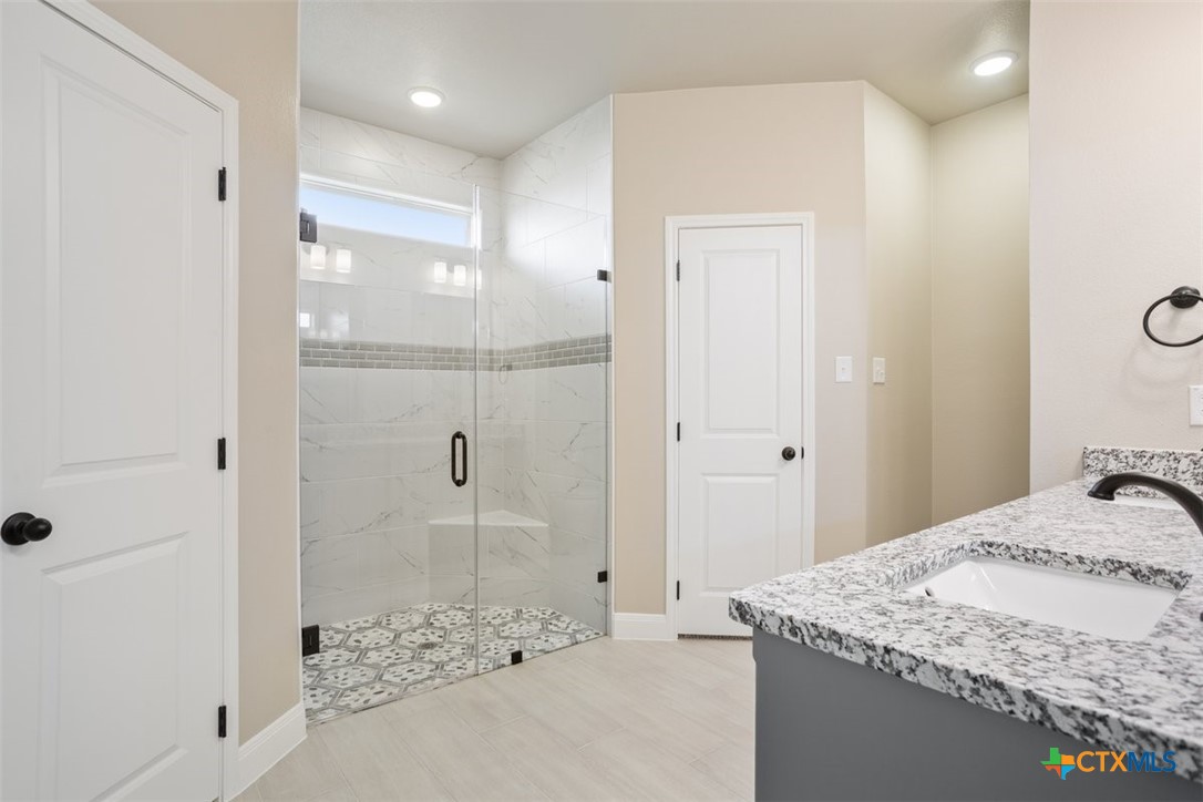 3824 Keller Road Temple, TX 76504 - Photo 17 of 28 a bathroom with a granite countertop sink a mirror and shower