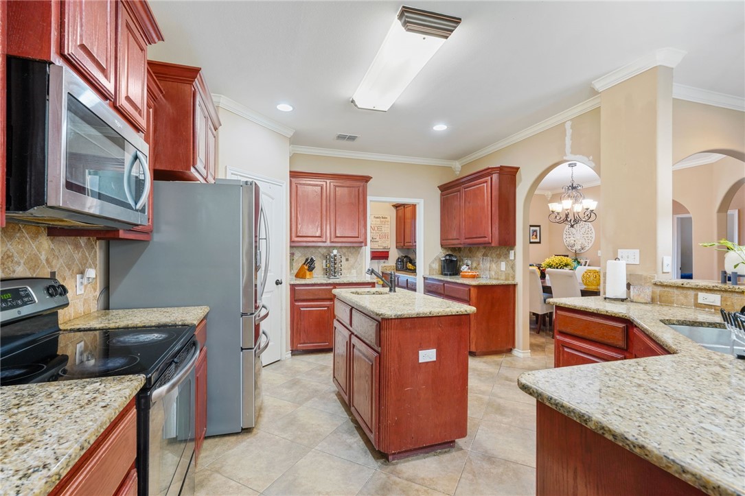 8226 Azimuth Court Corpus Christi, TX 78414 - Photo 11 of 32 a kitchen with stainless steel appliances granite countertop a stove a refrigerator a sink and dishwasher