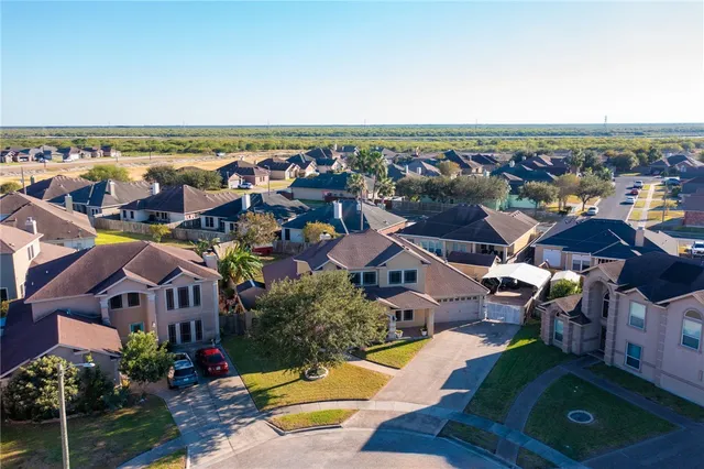 an aerial view of ocean and residential houses with outdoor space