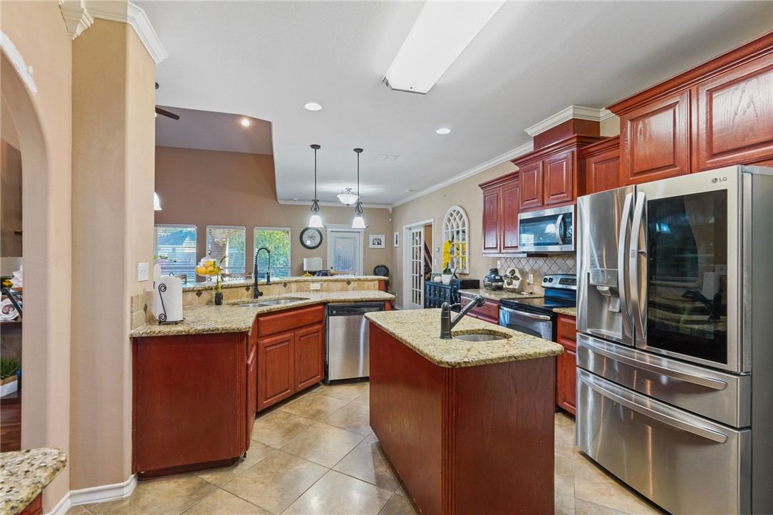 8226 Azimuth Court Corpus Christi, TX 78414 - Photo 10 of 32 a kitchen with kitchen island granite countertop stainless steel appliances and stove