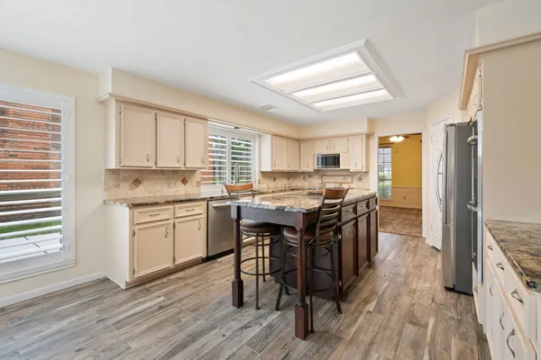 a kitchen with a sink stove a refrigerator and white cabinets
