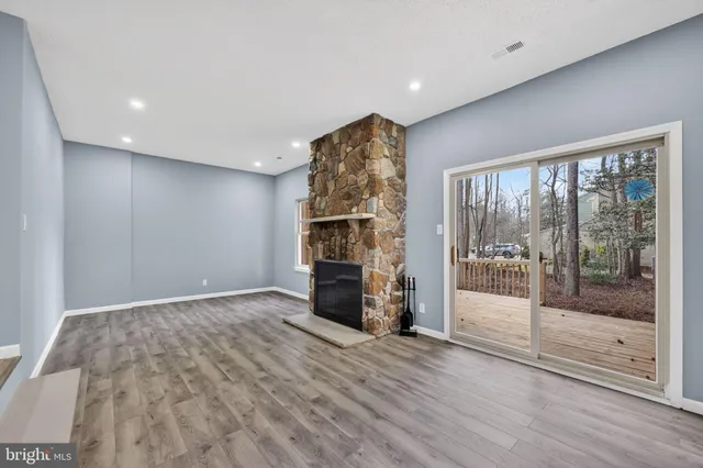 a view of empty room with wooden floor and fireplace