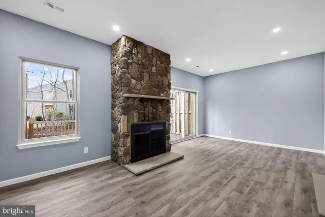 a view of an empty room with a window and fireplace