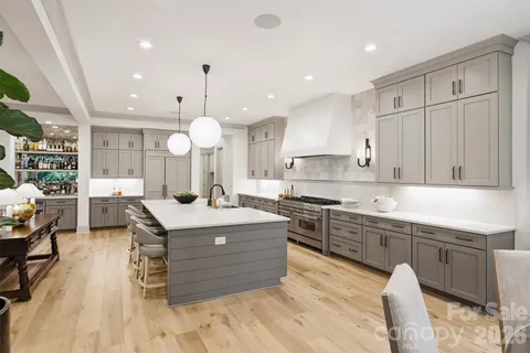 a large kitchen with stainless steel appliances granite countertop a stove a sink dishwasher and a dining table with wooden cabinet