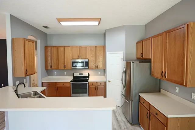 a kitchen with stainless steel appliances a refrigerator sink and microwave