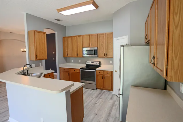 a kitchen with stainless steel appliances a refrigerator stove and sink