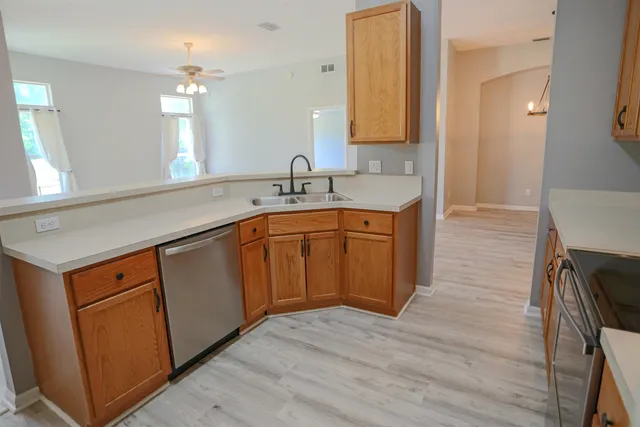 a kitchen with a sink cabinets and wooden floor