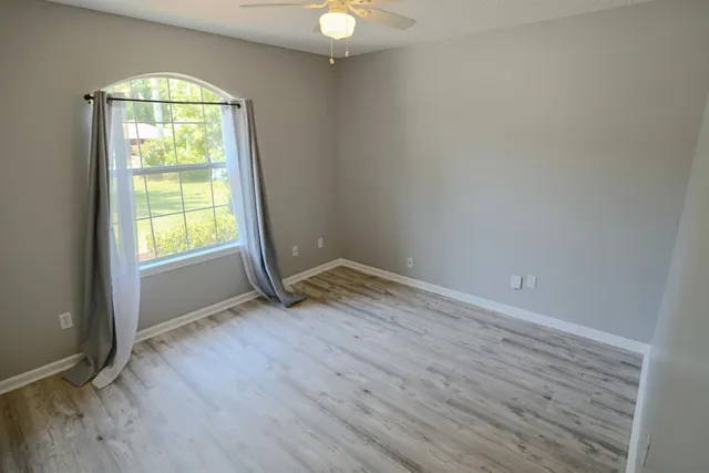 a view of an empty room with wooden floor