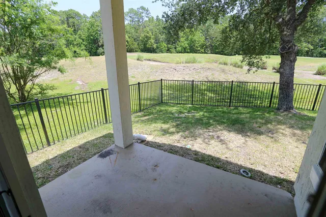 a view of a house with backyard and tree