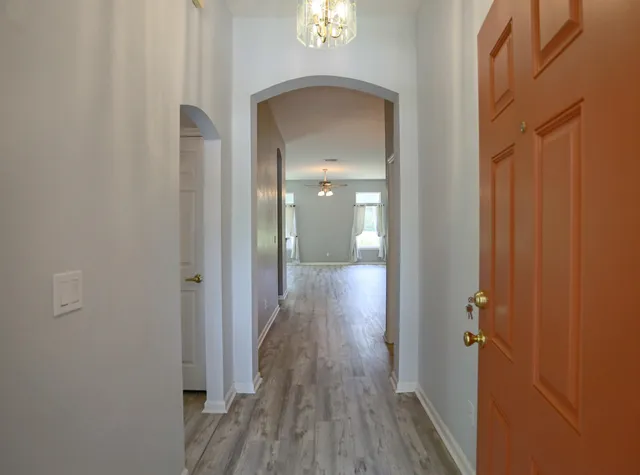 a view of a hallway with wooden floor and closet area