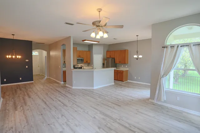 a view of a kitchen with wooden floor and a ceiling fan