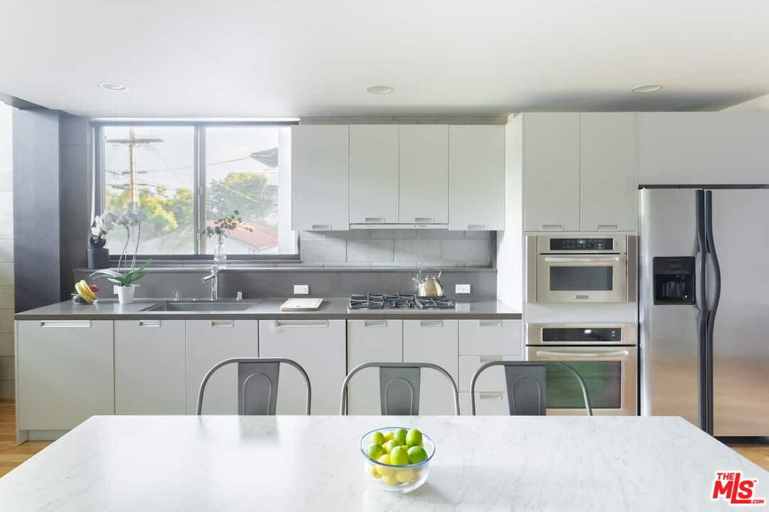 530 North Larchmont Boulevard, Unit 4 Los Angeles, CA 90004 - Photo 4 of 18 a kitchen with stainless steel appliances a sink a stove a refrigerator and cabinets