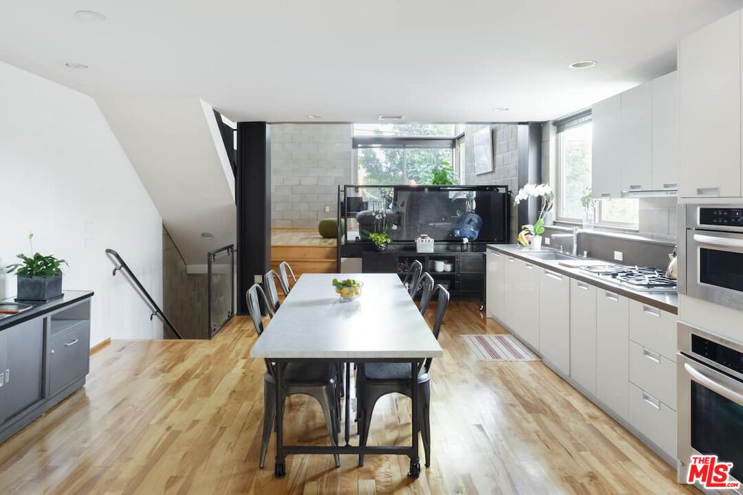 530 North Larchmont Boulevard, Unit 4 Los Angeles, CA 90004 - Photo 7 of 18 a kitchen with stainless steel appliances granite countertop a stove top oven a sink dishwasher and white cabinets with wooden floor