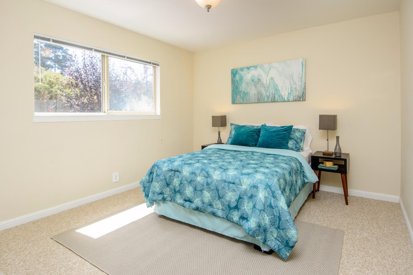 416 Cullen Road Pacifica, CA 94044 - Photo 11 of 18 a bedroom with a bed and painting on the wall