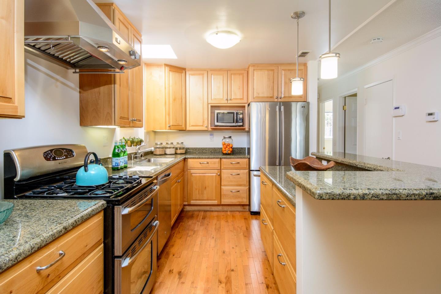 416 Cullen Road Pacifica, CA 94044 - Photo 4 of 18 a kitchen with granite countertop a sink a counter top space appliances and cabinets