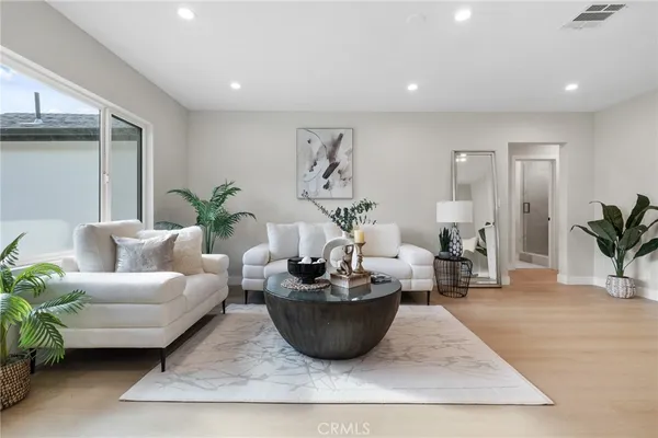 a living room with furniture potted plant and window