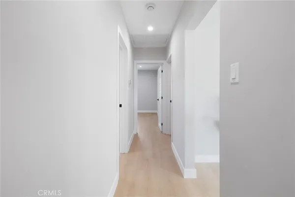 a view of a hallway with wooden shelves
